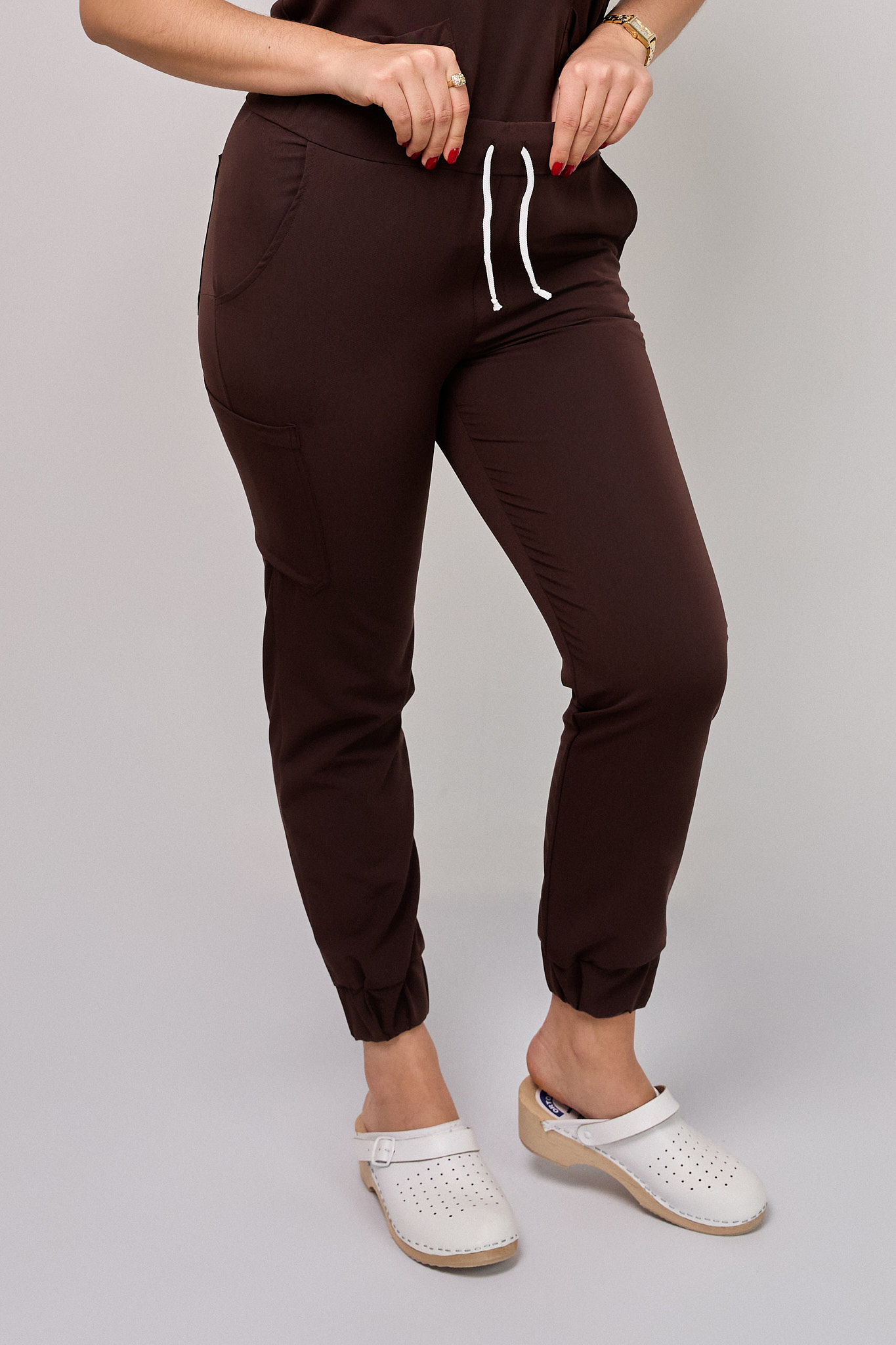 Spodnie_medyczne_damskie_Cosmo_Flex_kolor_czekolada3 Komplet medyczny damski Medicstar Cosmo Super Flex: Bluza medyczna damska Atena Medicstar Cosmo Super Flex czekolada Cechy charakterystyczne: Sportowa, nowoczesna stylizacja — idealna dla aktywnych zawodowo kobiet ceniących modny wygląd Elastyczna, mięsista tkanina wysokiej jakości z — miękka w dotyku, dobrze dopasowująca się do sylwetki Solidne, podwójne przeszycia w newralgicznych miejscach — zwiększają trwałość i wytrzymałość bluzy Skład materiału: 67% poliester 27% viscose 6% spandex (elastan) Gramatura: 200 g/m² — optymalna grubość zapewniająca trwałość i komfort noszenia