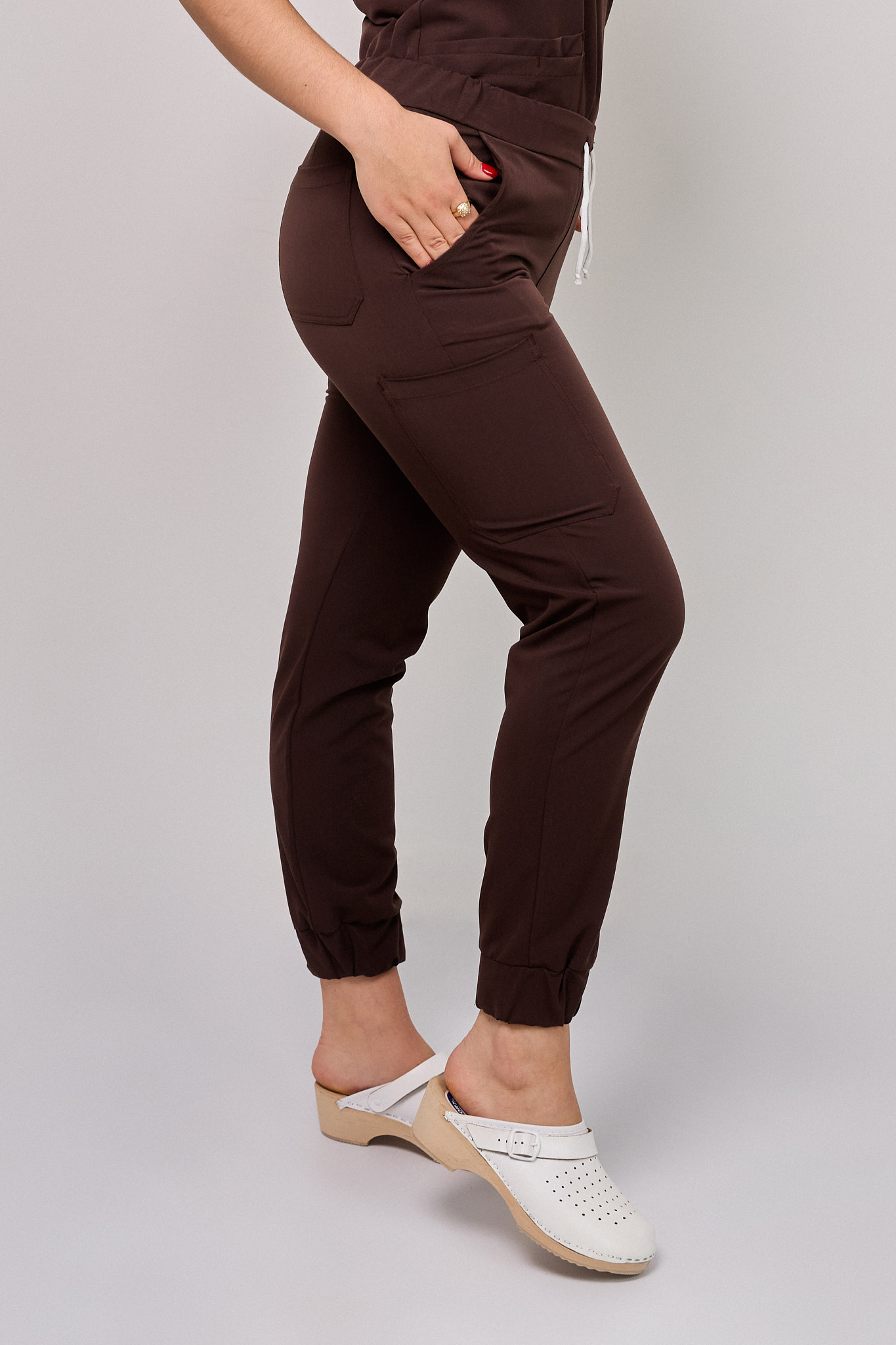 Spodnie_medyczne_damskie_Cosmo_Flex_kolor_czekolada4 Komplet medyczny damski Medicstar Cosmo Super Flex: Bluza medyczna damska Atena Medicstar Cosmo Super Flex czekolada Cechy charakterystyczne: Sportowa, nowoczesna stylizacja — idealna dla aktywnych zawodowo kobiet ceniących modny wygląd Elastyczna, mięsista tkanina wysokiej jakości z — miękka w dotyku, dobrze dopasowująca się do sylwetki Solidne, podwójne przeszycia w newralgicznych miejscach — zwiększają trwałość i wytrzymałość bluzy Skład materiału: 67% poliester 27% viscose 6% spandex (elastan) Gramatura: 200 g/m² — optymalna grubość zapewniająca trwałość i komfort noszenia