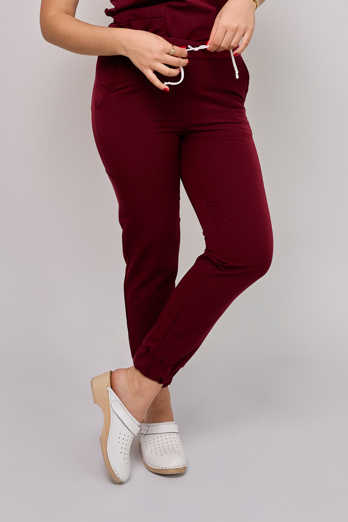 Komplet medyczny damski Medicstar Cosmo Super Flex: Bluza medyczna damska Atena Medicstar Cosmo Super Flex bordo Cechy charakterystyczne: Sportowa, nowoczesna stylizacja — idealna dla aktywnych zawodowo kobiet ceniących modny wygląd Elastyczna, mięsista tkanina wysokiej jakości z  — miękka w dotyku, dobrze dopasowująca się do sylwetki Solidne, podwójne przeszycia w newralgicznych miejscach — zwiększają trwałość i wytrzymałość bluzy Skład materiału: 67% poliester 27% viscose 6% spandex (elastan) Gramatura: 200 g/m² — optymalna grubość zapewniająca trwałość i komfort noszenia Spodnie medyczne damskie Joggery Cosmo Flex bordo Cechy charakterystyczne: Sportowa, nowoczesna stylizacja — idealna dla aktywnych zawodowo kobiet ceniących modny wygląd Elastyczna, mięsista tkanina wysokiej jakości z przewagą bawełny  domieszką poliestru i elastanu — miękka w dotyku, dobrze dopasowująca się do sylwetki Solidne, podwójne przeszycia w newralgicznych miejscach — zwiększają trwałość i wytrzymałość spodni Zalecana temperatura prania: Do 40°C — aby zachować jakość i koloryt tkaniny